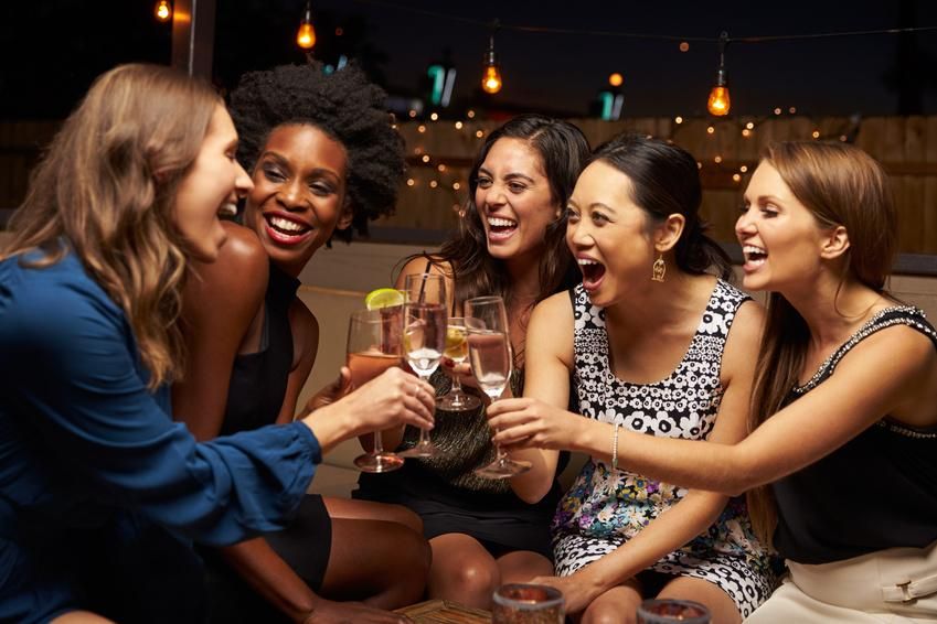 weekend outfits Group Of Female Friends Enjoying Night Out At Rooftop Bar